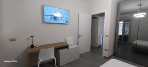 a room with a desk and a television on the wall at La casa di Tommy in Cortona