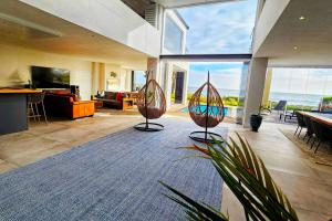 two sculptures in a living room with a view of the ocean at Villa Swart in Stompneusbaai
