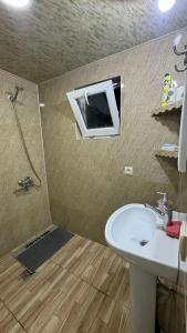 a bathroom with a sink and a tv on the wall at Farielli Guesthouse in Mestia