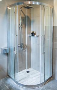 a shower with a glass door in a bathroom at La Pearl Mathiveri in Mathiveri