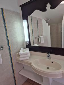 a bathroom with a sink and a mirror at Studio Ti Gwama Village Vacances in Sainte-Anne