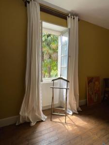 a window with white curtains in a room at Maison de Famille Les Tourelles in Tour-de-Faure