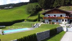 a house in a green hill with a swimming pool at Unterbleiwanghof in Radstadt