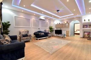 a living room with couches and a tv and a ceiling at شاليهات درة المئة in Ḩajlah