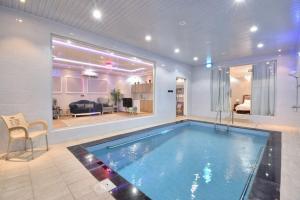 a large swimming pool in a room with a living room at شاليهات درة المئة in Ḩajlah