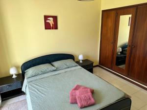 a bedroom with a bed with a pink towel on it at Vagueira beach in Praia da Vagueira