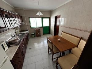 a kitchen with a wooden table and a dining room at Vagueira beach in Praia da Vagueira +7 photos