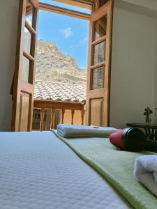 una cama en una habitación con vista a la montaña en Qente Wings, en Ollantaytambo
