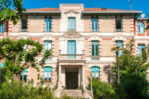 an old building with trees in front of it at Résidence de Tourisme Vacances Bleues Villa Regina in Arcachon