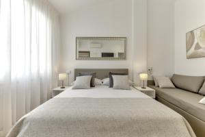 パドヴァにあるPrato della Valle 34 Apartmentsの大きなベッドとソファのある寝室