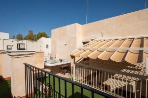 a balcony with a patio umbrella on a building at Apartamentos Gravina 56 in Seville