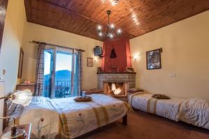 two beds in a room with a fireplace at To Aidoni in Karpenision