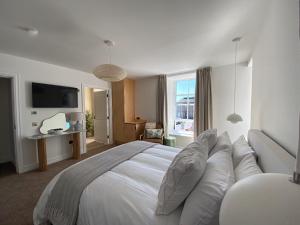 a bedroom with a large white bed and a television at Somerled House in Portree