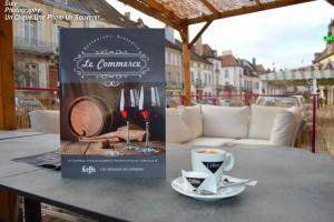 a sign on a table with a cup of coffee at Hôtel du Commerce in Semur-en-Auxois