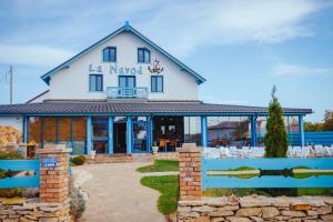 a building with a blue fence in front of it at La Navod Jurilovca in Jurilovca