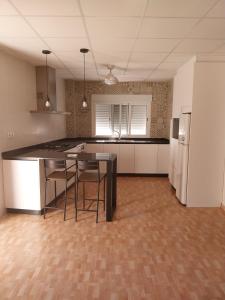 an empty kitchen with a table and a refrigerator at VENTA PURA in Águilas +10 photos