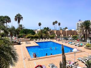 a swimming pool with people in a resort at Cactus Apartment in Playa Fañabe