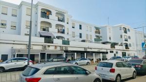 a parking lot with cars parked in front of a building at Espacioso apartamento en Barbate con Wifi in Barbate