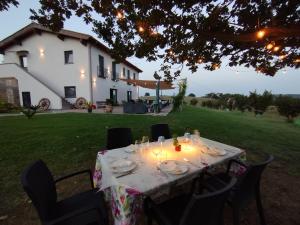 a table with plates and candles on it in front of a house at Agriturismo Casale Lisalola in Sutri