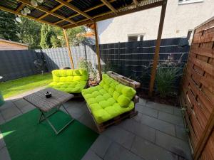 a pergola with green chairs and a table on a patio at Haushälfte nähe Volksparkstadion in Hamburg in Hamburg