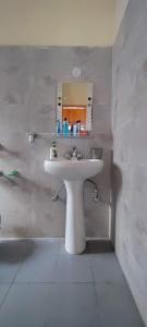 a bathroom with a white sink and a mirror at Vidhi homestay in Kulu