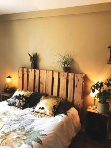 een bed met een houten hoofdeinde in een slaapkamer bij Superbe appartement T3 dans l'hyper centre in Blois