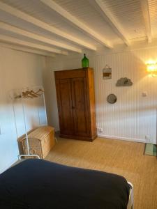 a bedroom with a bed and a green vase on the wall at Cottage en vignoble in Leynes