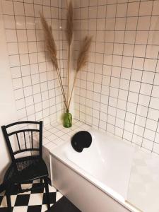 een stoel naast een bad met een plant bij Superbe appartement T3 dans l'hyper centre in Blois