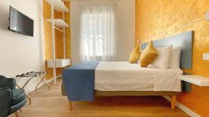 a bedroom with a large bed with yellow pillows at Color Houses Pescara Centro in Pescara