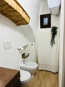 a white bathroom with a toilet and a sink at La Buona Volta in Montalbano Ionico