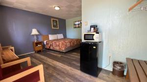 a hotel room with a bed and a microwave at Northland Motel Bay City-Kawkawlin in Kawkawlin