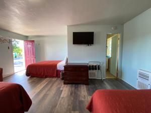 a hotel room with two beds and a flat screen tv at Northland Motel Bay City-Kawkawlin in Kawkawlin