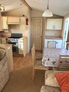 a kitchen and living room with a table and chairs at Cranfield Caravan Retreat in Lisnacree