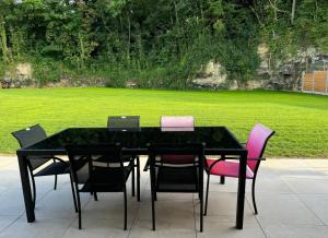 a black table and chairs with laptops on top at Maison Privée, Calme, parking, Jardin in Reviers