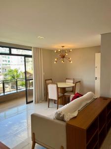 Un dormitorio con una cama y un comedor con una mesa. en Apartamento Charme Cabo Frio RJ, en Cabo Frío