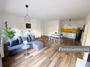 a living room with a blue couch and a kitchen at Hotel Zur Linde in Zschepplin