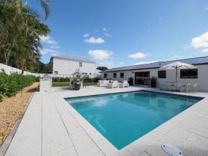 a swimming pool in the backyard of a house at NEW Luxury Mellow Marlin w Pool Jupiter FL in Jupiter