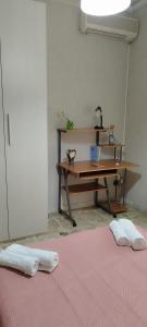 Habitación con escritorio y mesa con 2 toallas en A casa di Naty, en Gravina di Catania