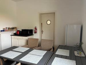 a kitchen with a table with chairs and a refrigerator at Zimmer für 2 Personen-Bad-Kühlschrank-TV-11 in Meine +13 photos