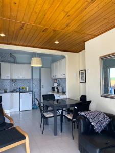 a dining room and kitchen with a table and chairs at Casa do Portão Azul - Espadarte in Atouguia da Baleia