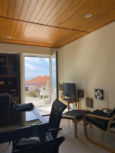 sala de estar con sillas y puerta corredera de cristal en Casa do Portão Azul - Espadarte, en Atouguia da Baleia