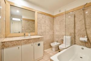 a bathroom with a tub and a toilet and a sink at Madalena EXCLUSIVE SUITES in Lisbon +60 photos