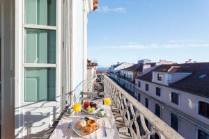 a table with plates of food on a balcony at Madalena EXCLUSIVE SUITES in Lisbon