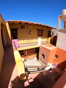una silla en el balcón de un edificio en Loma Tika - Tilcara Hostel, en Tilcara 50 fotos más