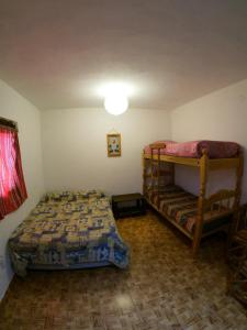 1 dormitorio con 2 literas y lámpara en Loma Tika - Tilcara Hostel, en Tilcara