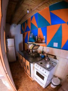 a kitchen with a stove and a colorful wall at Loma Tika - Tilcara Hostel in Tilcara +42 photos