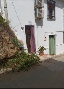 a white building with a door and a window at La madrileña 2 in Casabermeja