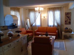 Sala de estar con 2 sillas de color naranja y mesa en Garden Villa, en Ioannina