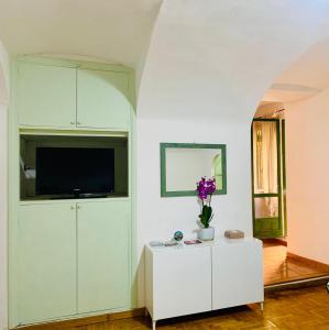 sala de estar con TV y armario blanco en Vacanze Romane Colosseo apartment, en Roma