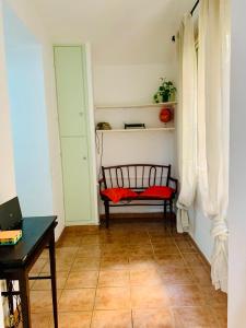 una habitación con un banco rojo y una mesa en Vacanze Romane Colosseo apartment, en Roma